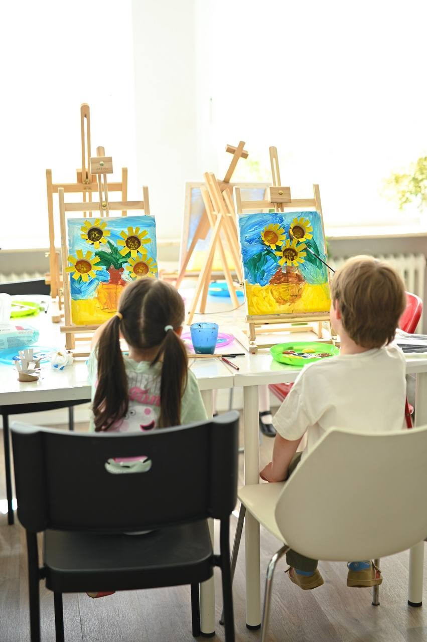 Kinder malen Sonnenblumen an der Staffelei