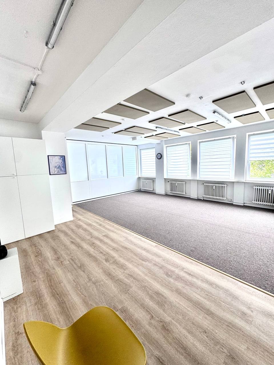 Großer Saal mit Teppich, Holzboden und Fensterfront