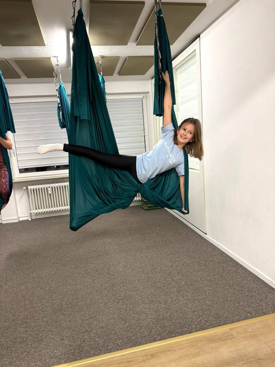 Mädchen lacht im Fly-Yoga-Tuch